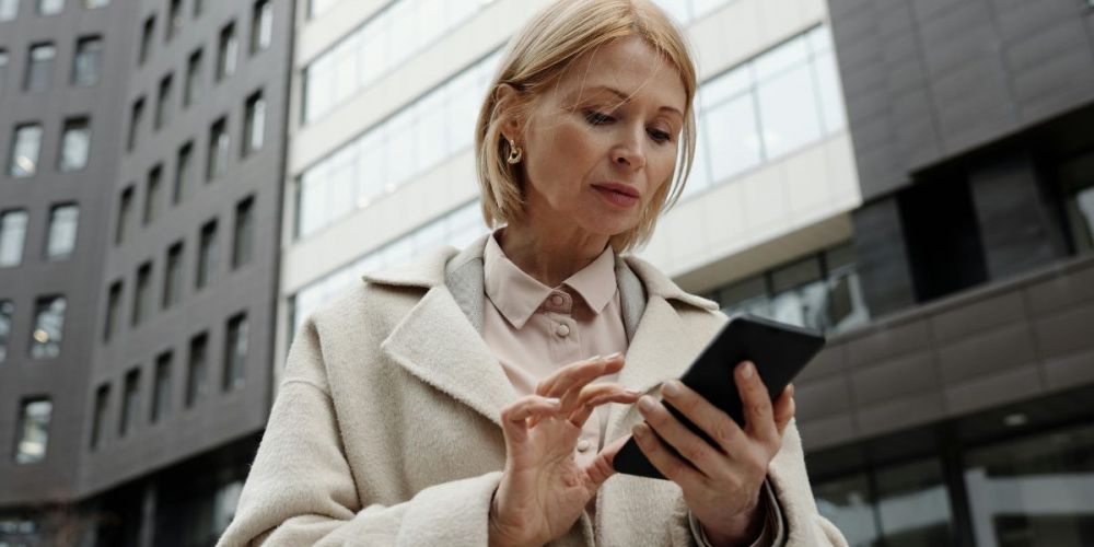 Facility manager using mobile phone outdoor to monitor facility management system
