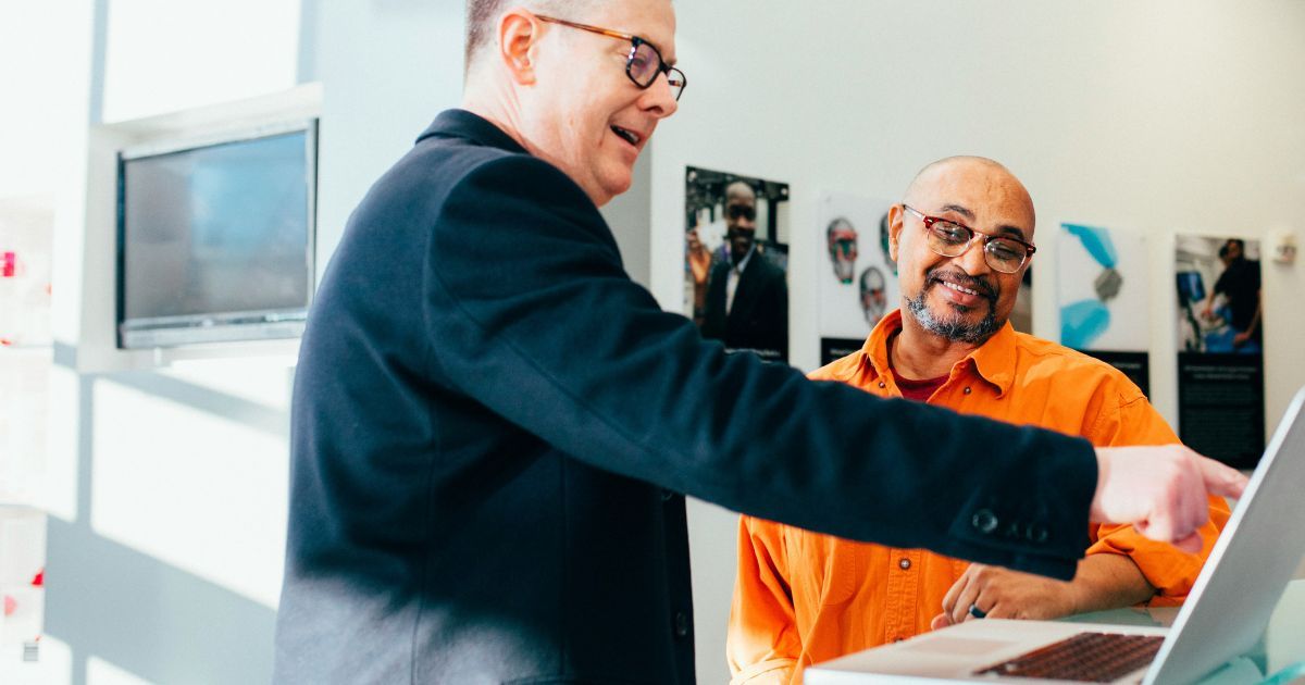 Professionals using laptop in modern workspace to access property management software