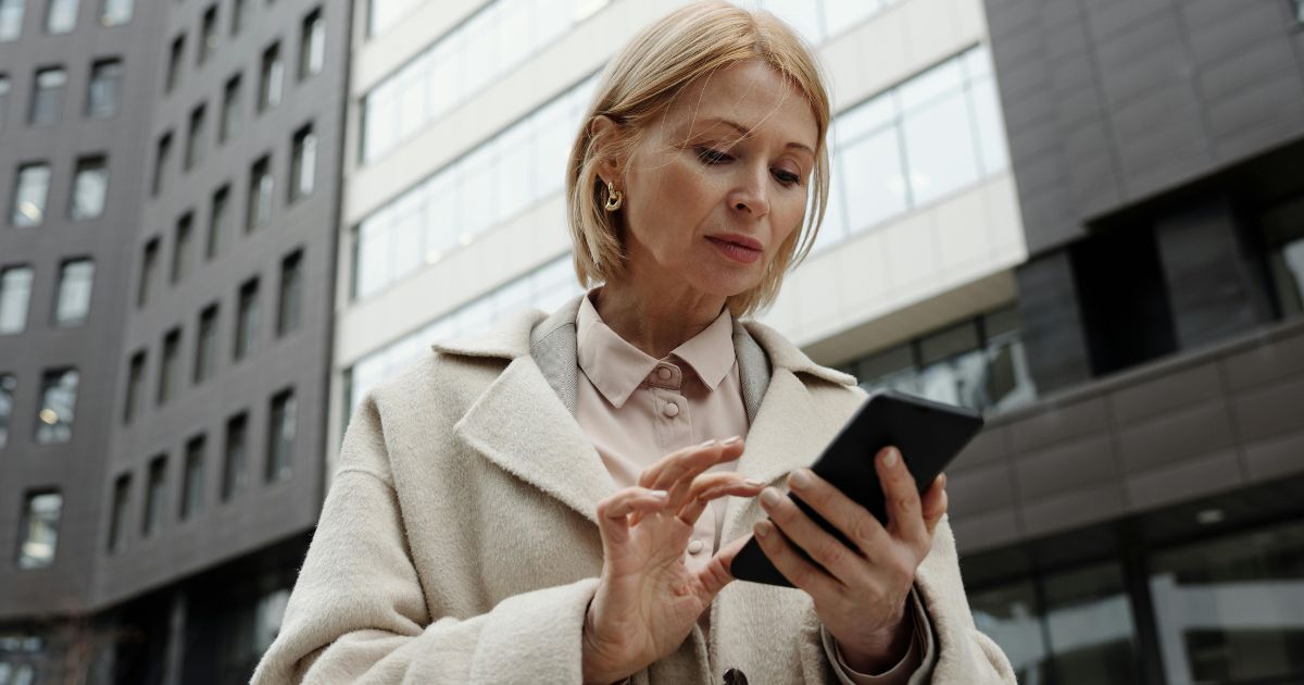 Facility manager using mobile phone outdoor to monitor facility management system