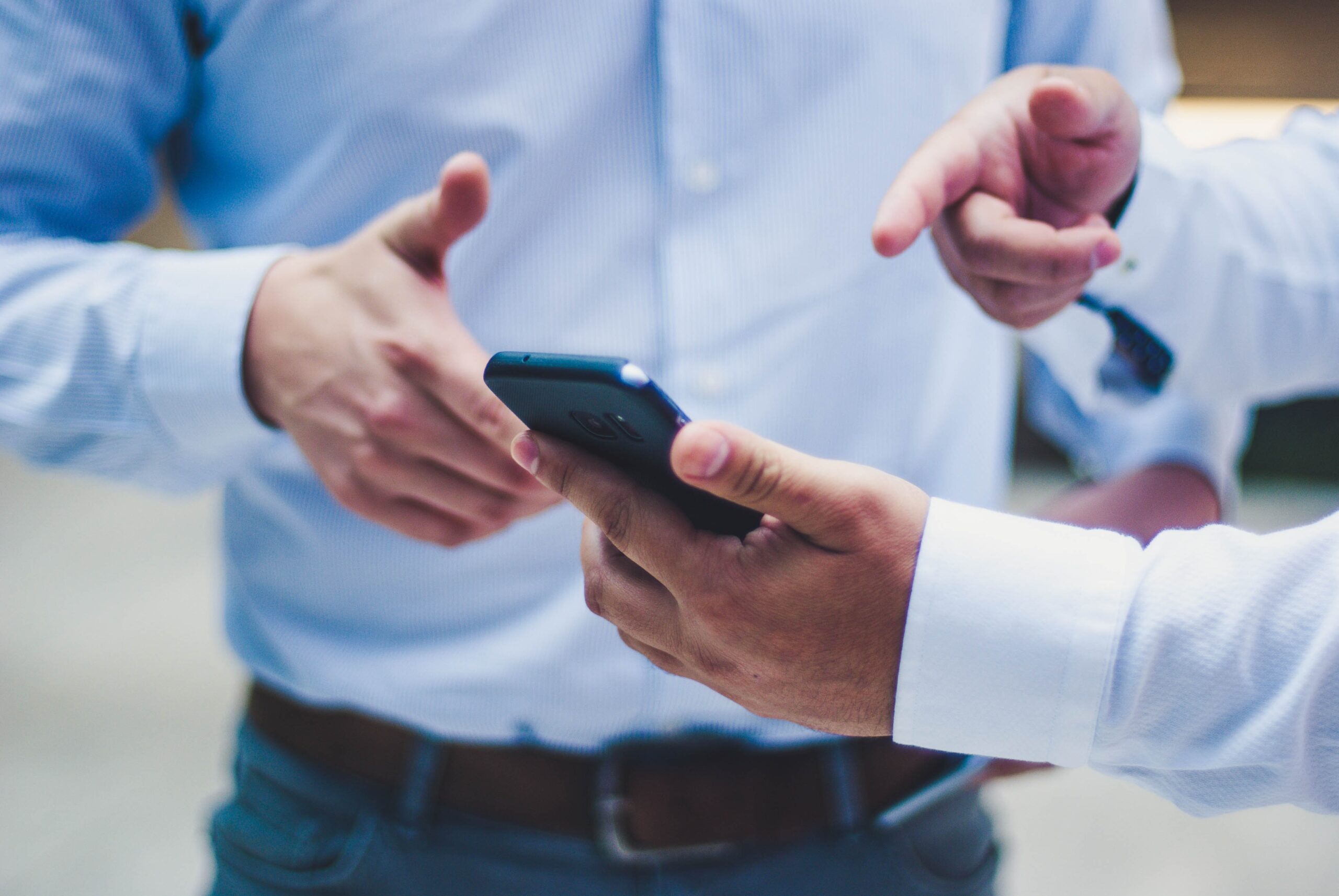 Professionals reviewing project details on smartphone using building management software