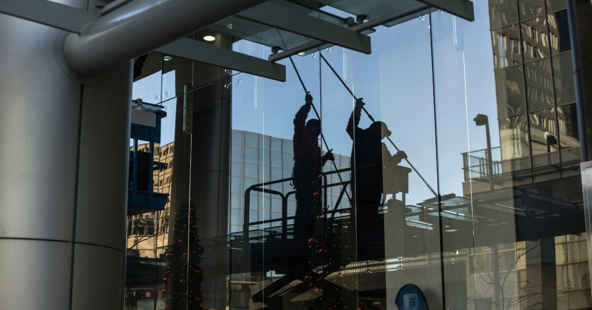 image of maintenance workers outside a building exterior