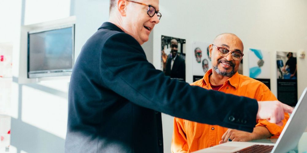 Professionals using laptop in modern workspace to access property management software