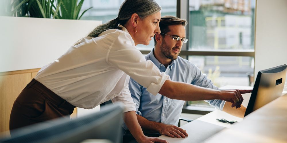 Professional woman using property management software on laptop in modern office space