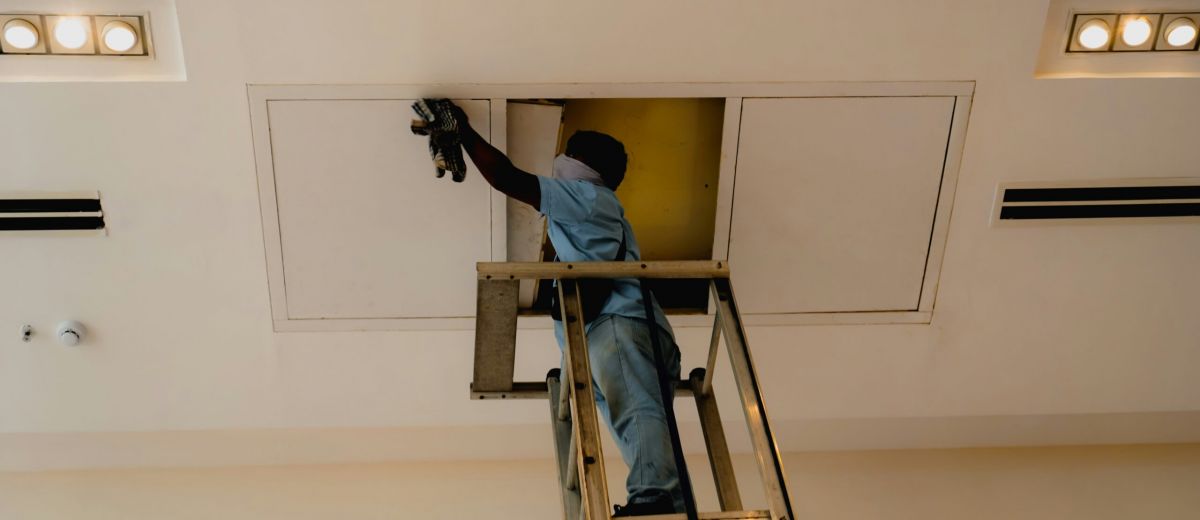 Maintenance technician inspecting a radiator in an apartment building