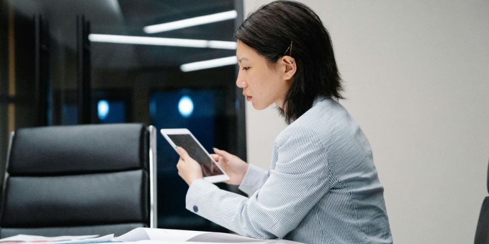 Professional using tablet indoors to manage facility management software